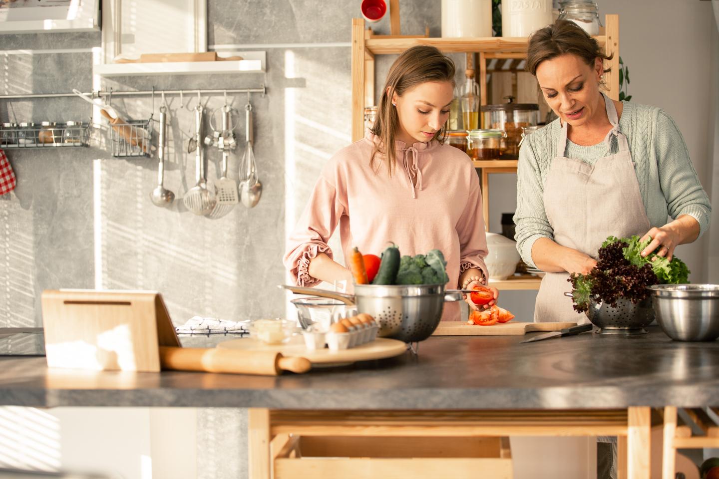 Two women preparing vegetables together in a kitchen